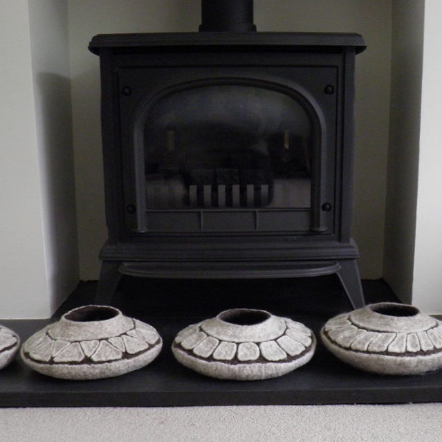 Felt pots sitting in front of a fireplace - FFelted